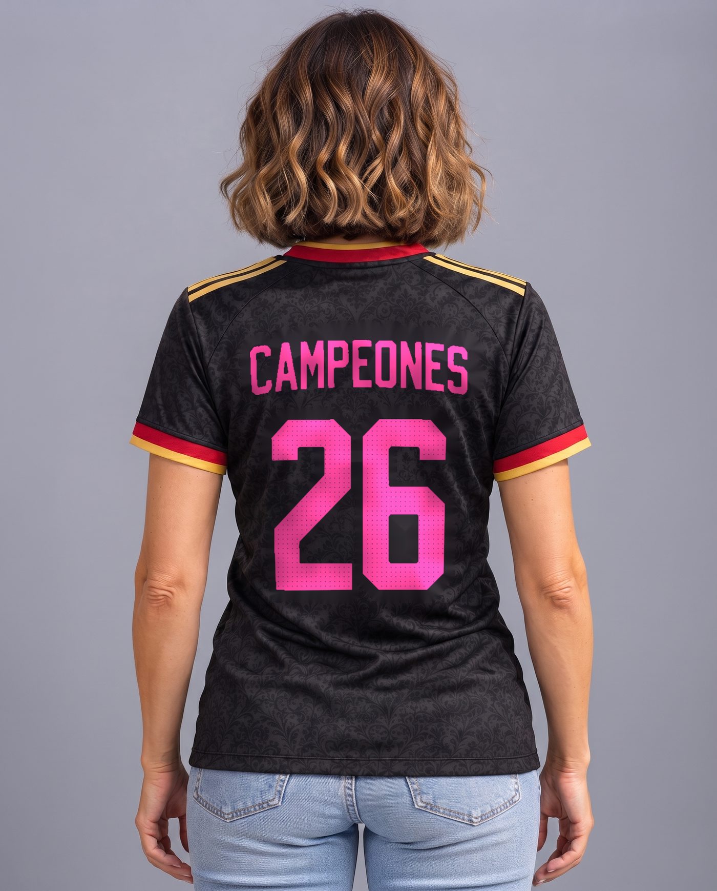 Back view wearing the women's black and pink Spain shirt, with the name Campeones and the number 26