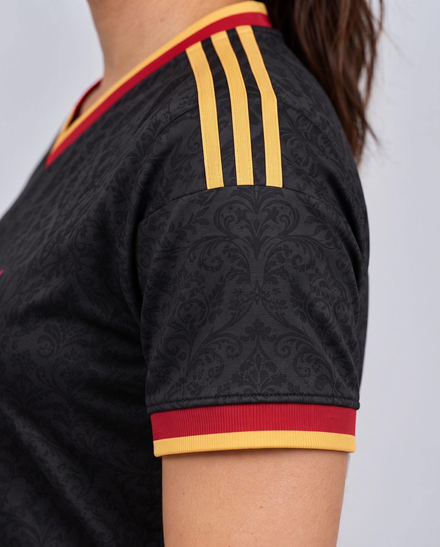 Close-up of the left sleeve, black with the red and gold cuff, of the Campeones 26 shirt