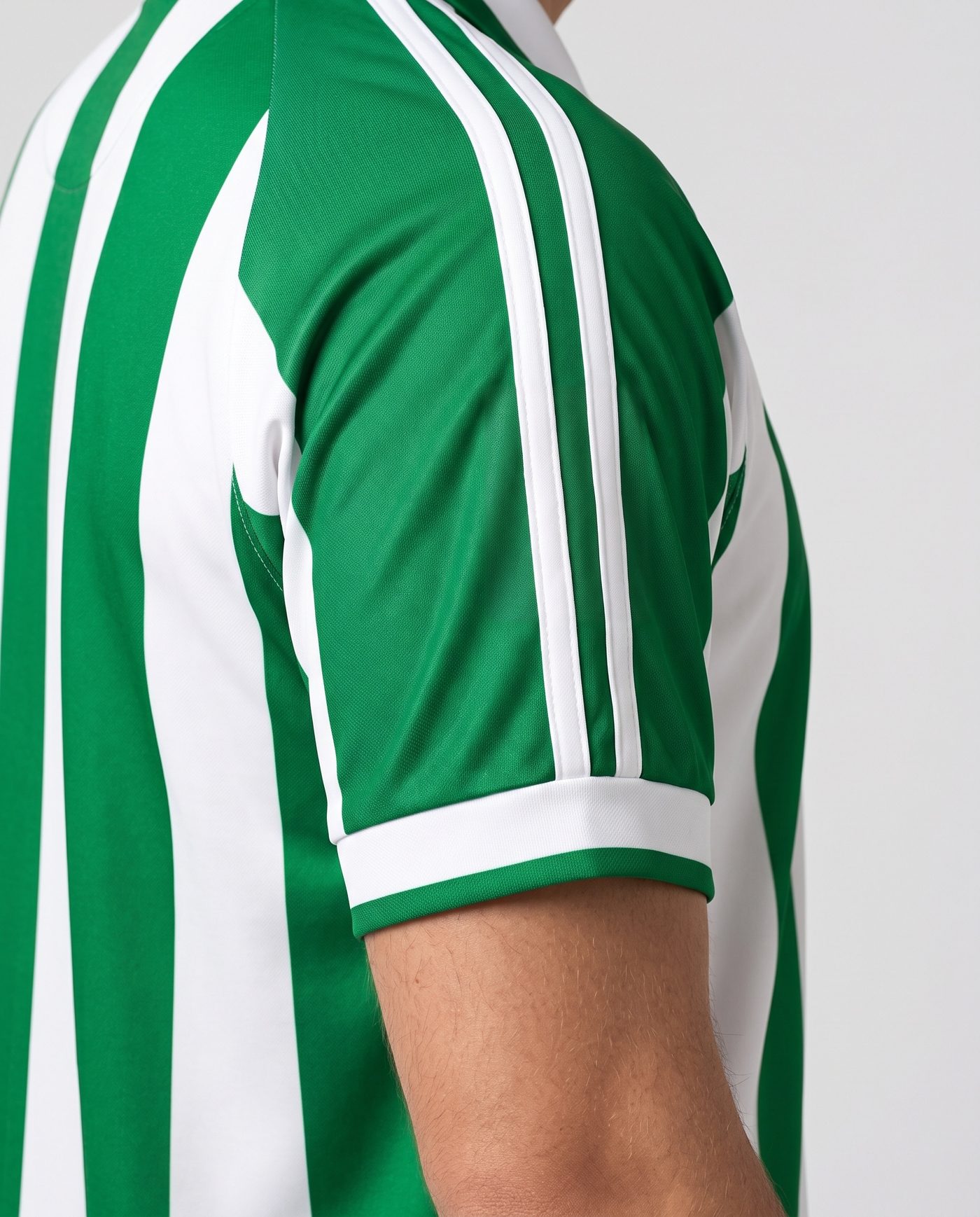 Close-up of the left sleeve, green with the two white stripes and no patches, of the Denilson 16 shirt