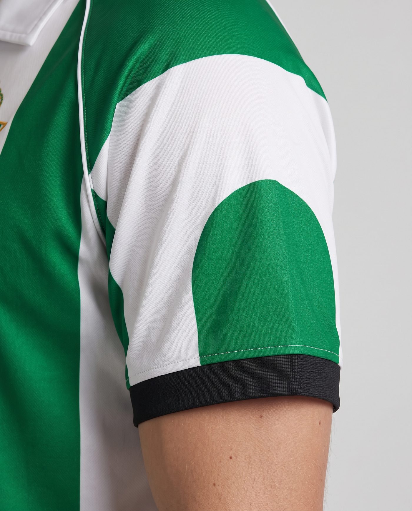Detalle de la manga izquierda, blanca con el arco verde y el puño negro, de la camiseta Finidi 25