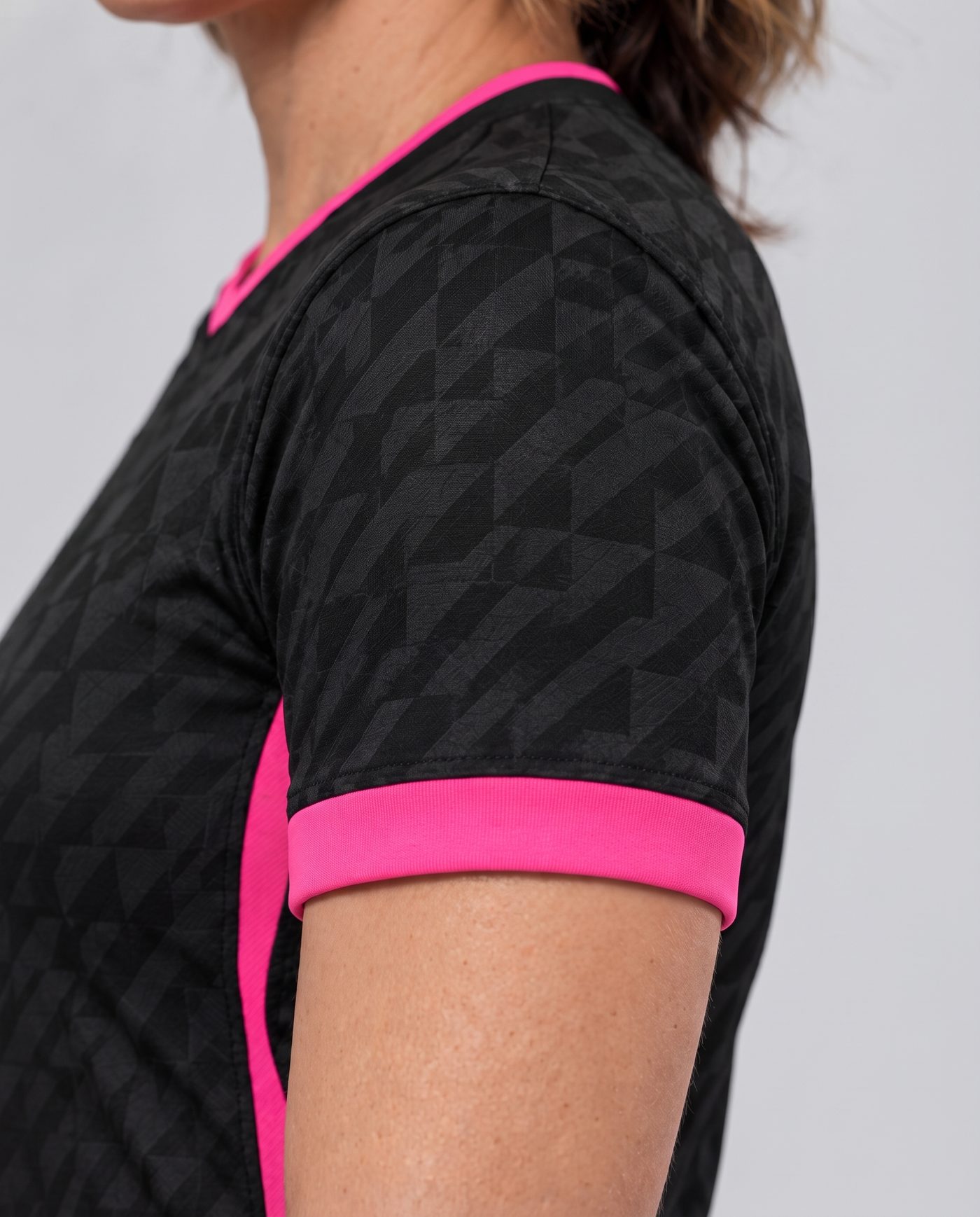 Close-up of the left sleeve, black with the geometric pattern and the pink cuff, of the Llorente 14 shirt