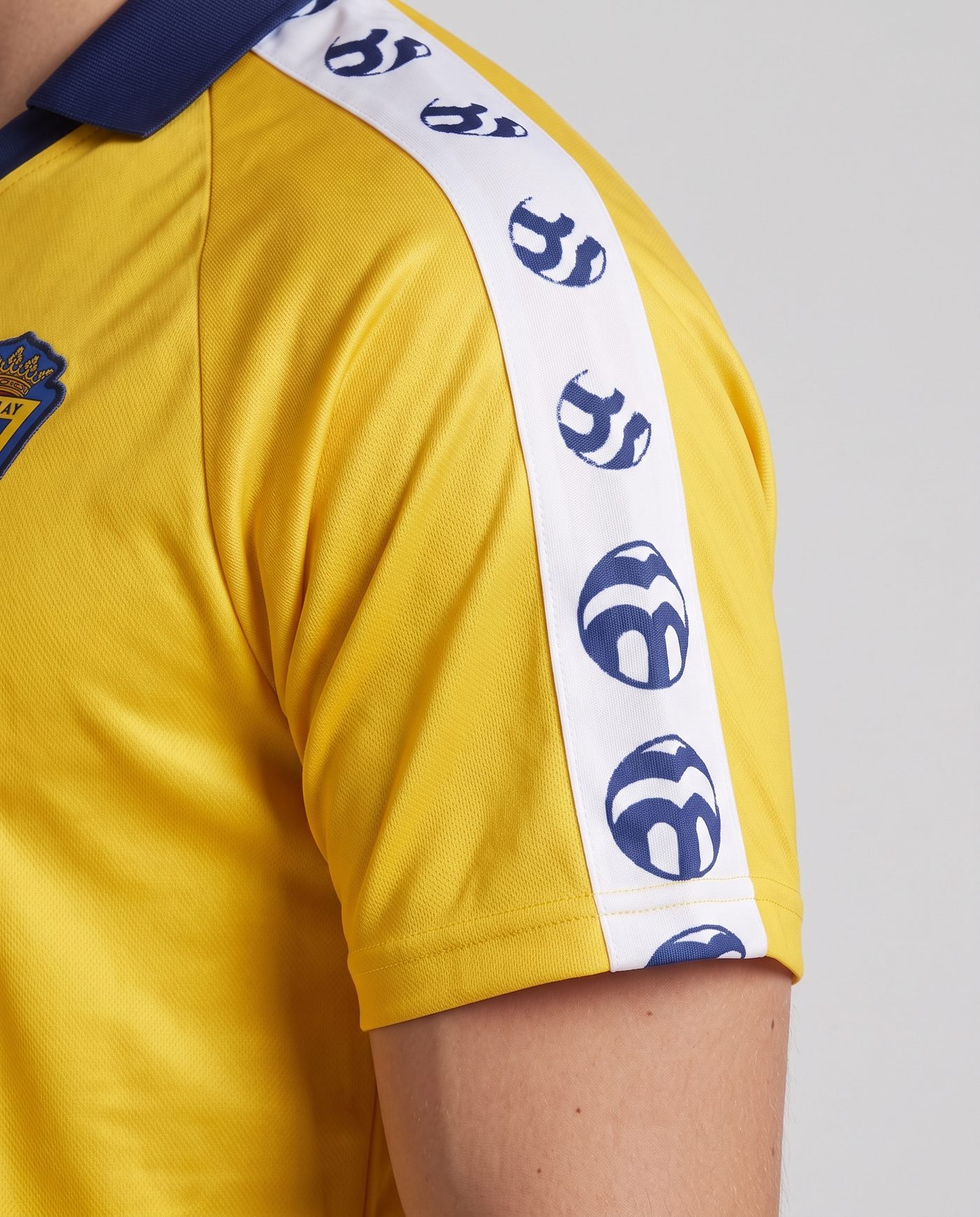 Close-up of the left sleeve, yellow with the white shoulder tape, of the Mágico 11 shirt