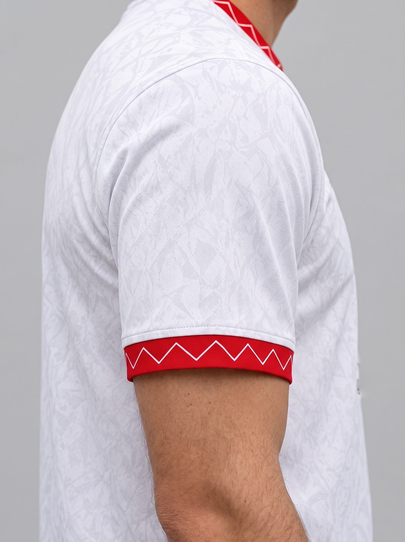 Detalle de la manga izquierda, blanca con el puño rojo de zigzag blanco, de la camiseta Pablo Alfaro 24