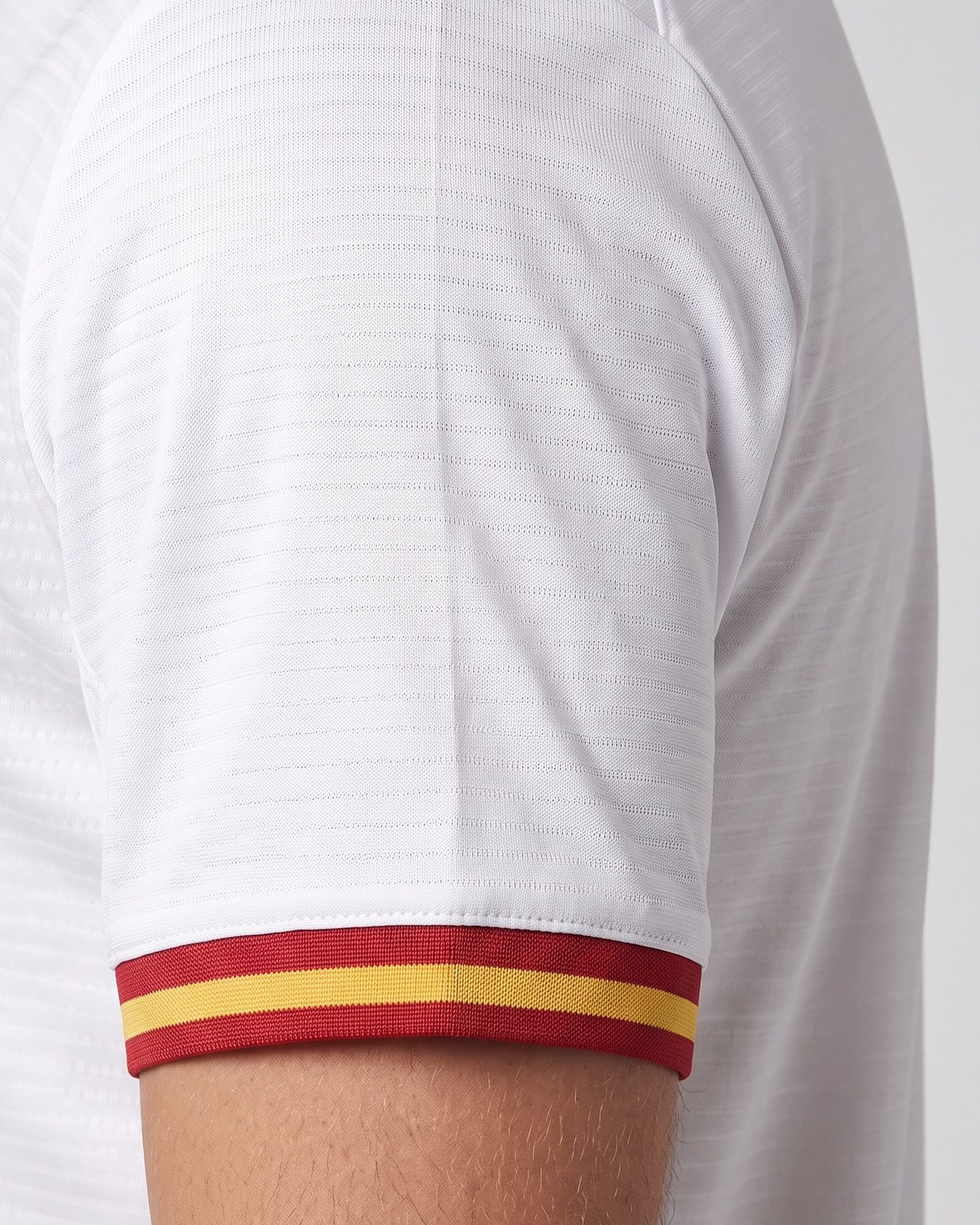 Detalle de la manga izquierda, blanca con el puño rojo y amarillo, de la camiseta Pirri 8