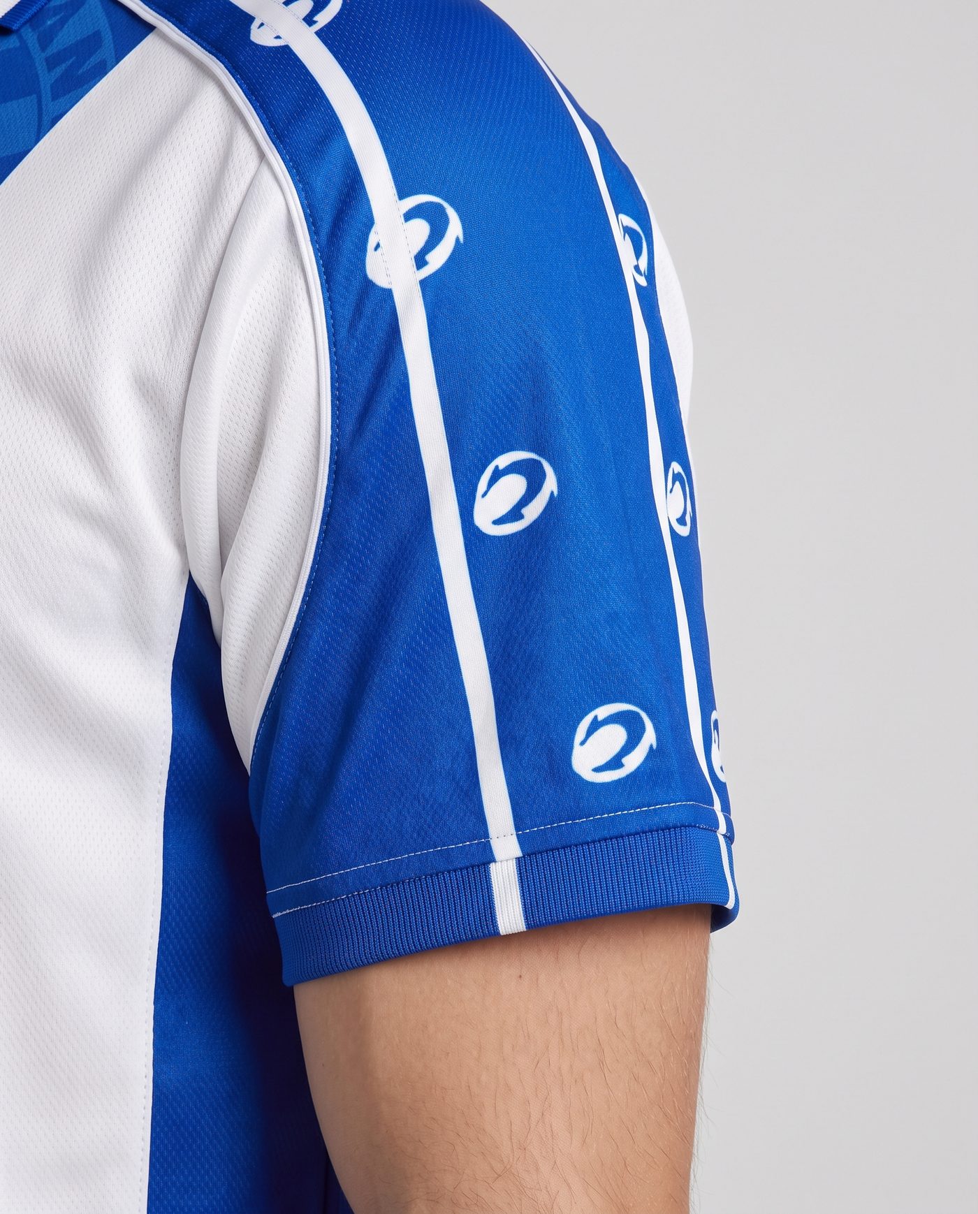 Close-up of the left sleeve, blue with the white stripes, of the Tamudo 23 shirt